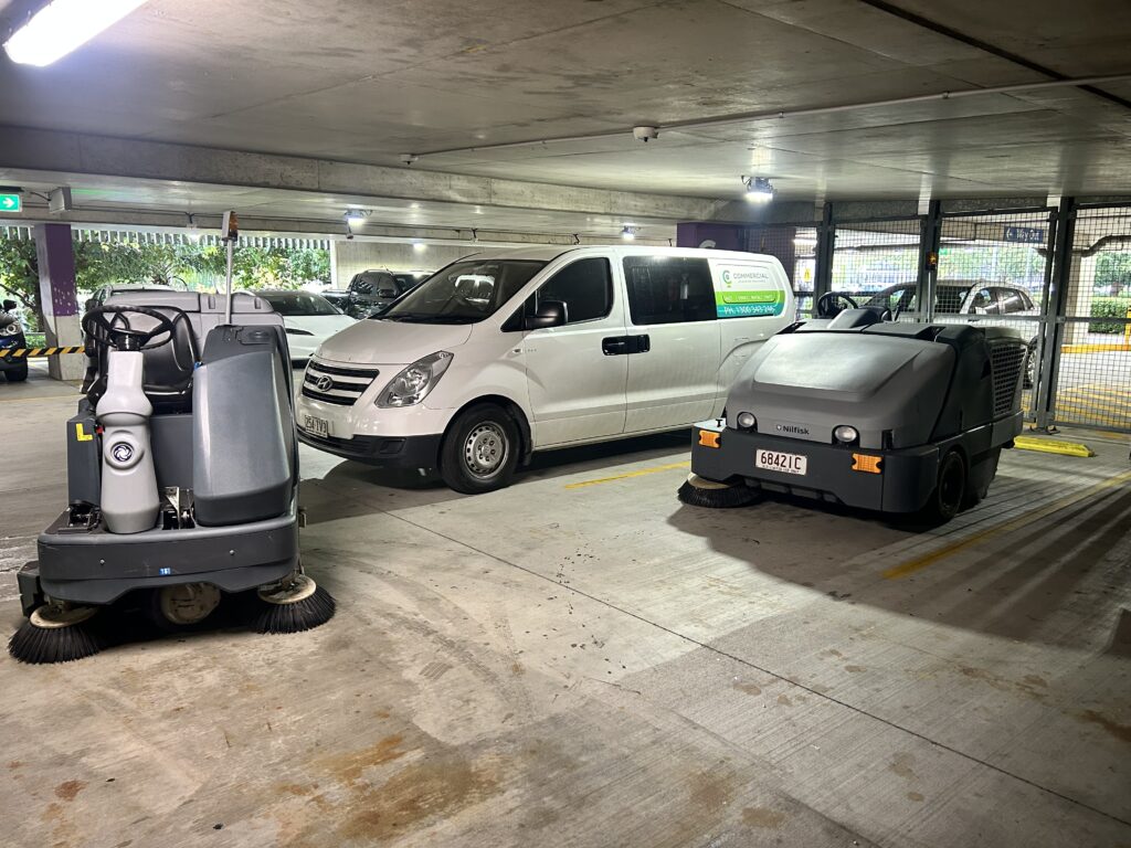 Nilfisk ride-on floor scrubber and sweeper with Commercial Cleaning Machines service van in Brisbane car park