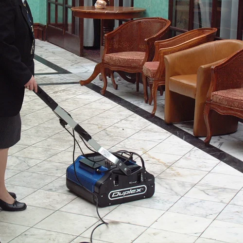 Operator cleaning a hotel tile floor with a Duplex 420 commercial floor scrubber