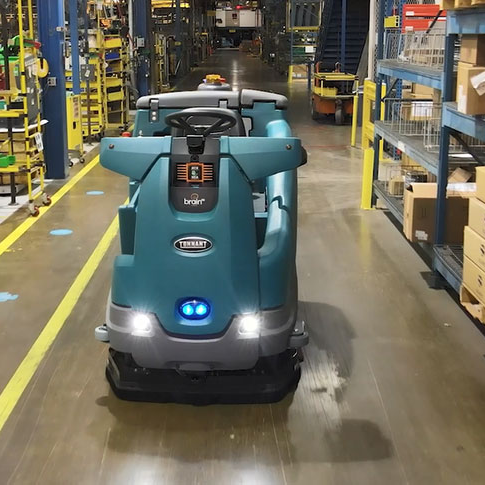 Tennant T16AMR robotic floor scrubber cleaning a warehouse aisle