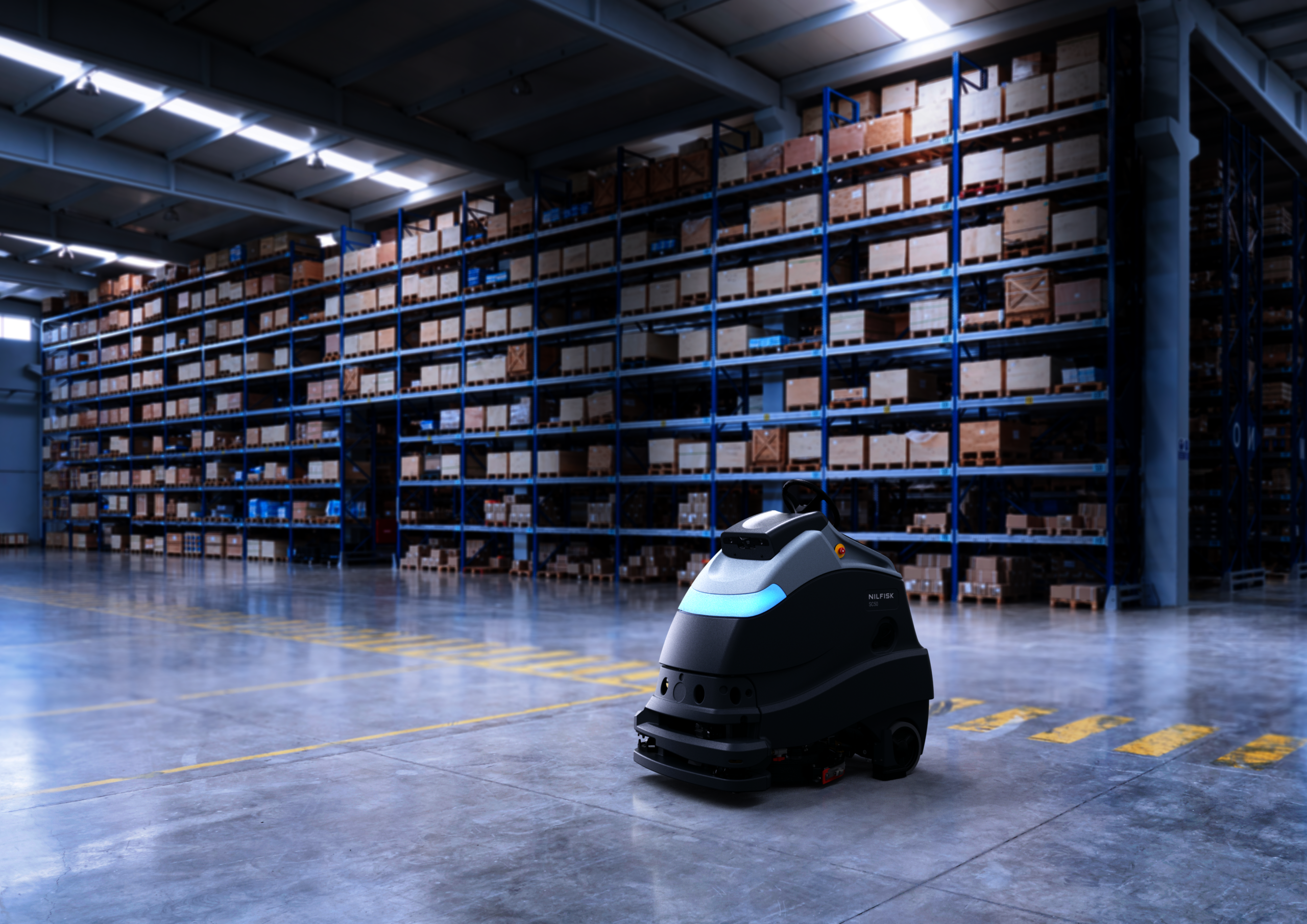 Nilfisk Liberty SC50 robotic floor scrubber cleaning a concrete floor in a warehouse.