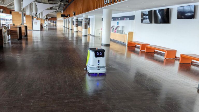 PUDU CC1 commercial cleaning robot autonomously cleaning a large indoor floor.
