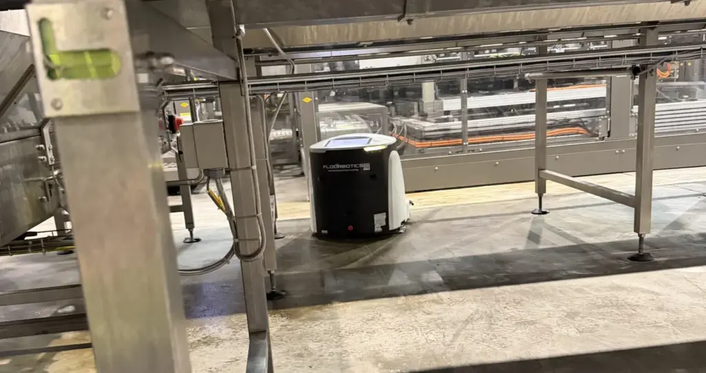 FloorBotics robotic floor scrubber running under a conveyor line in a Queensland manufacturing plant