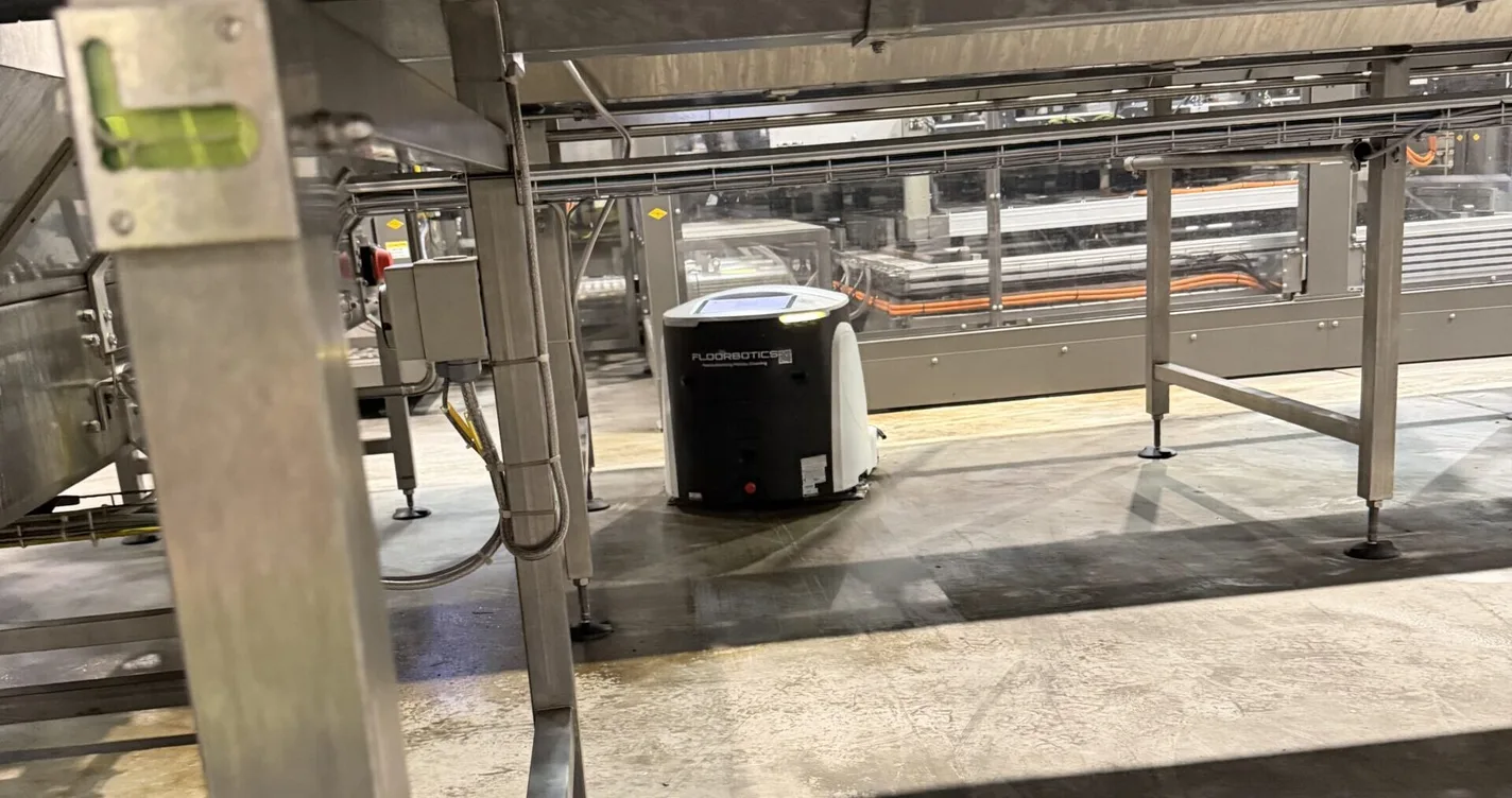 FloorBotics robotic floor scrubber running under a conveyor line in a Queensland manufacturing plant