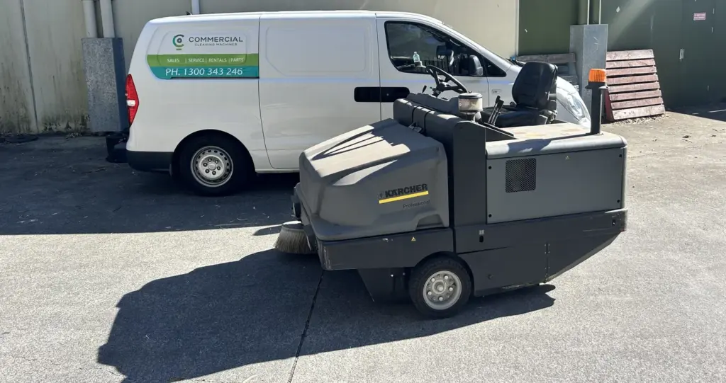 CC Machines service van parked beside a Karcher ride-on sweeper outside a Brisbane building